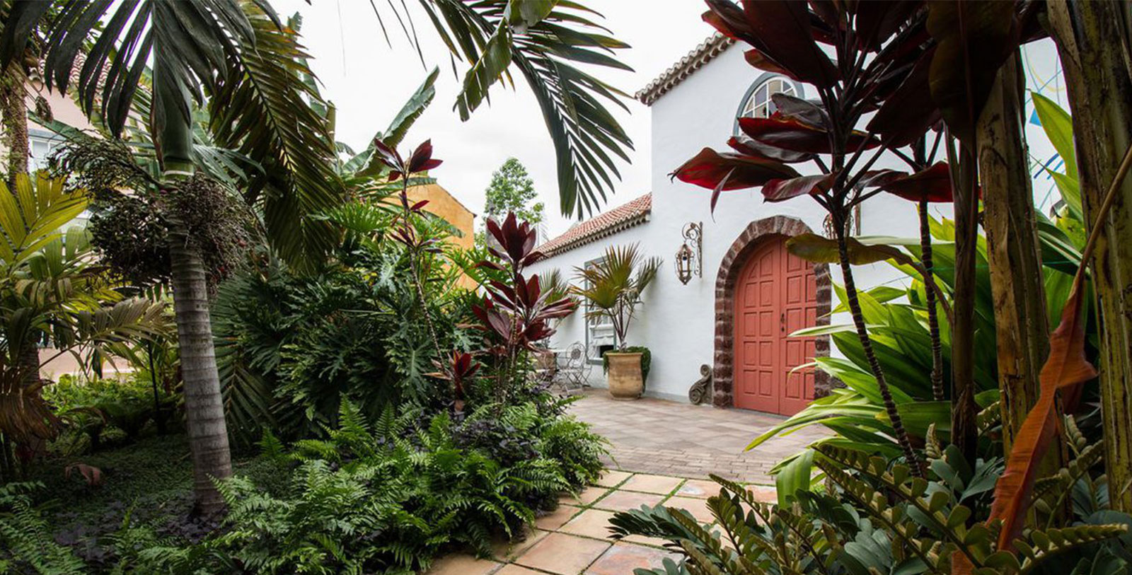 a house with plants and a red door