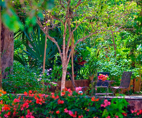 a patio with chairs and a table and a table with flowers