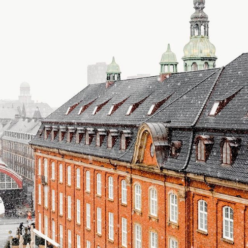 a building with a roof and a snow falling