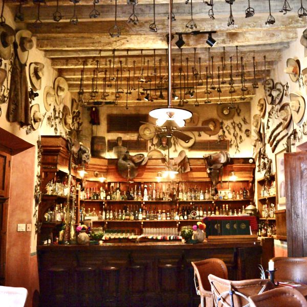 a room with a bar and cowboy hats