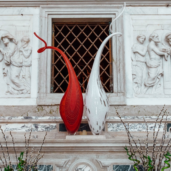 a red and white sculpture on a window sill