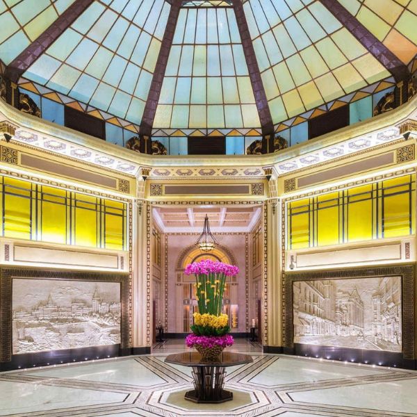 a large vase of flowers in a room with a glass dome ceiling