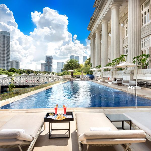 a pool with a bridge and a building with columns