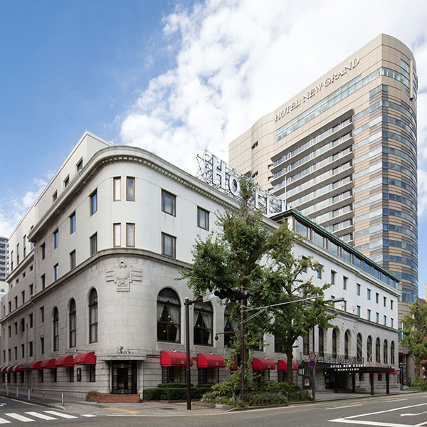 a building with red awnings and a tall building with a street corner