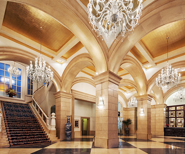 a large hall with stairs and chandeliers