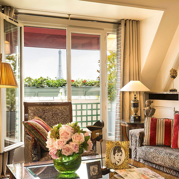 a living room with a glass door and a vase of flowers