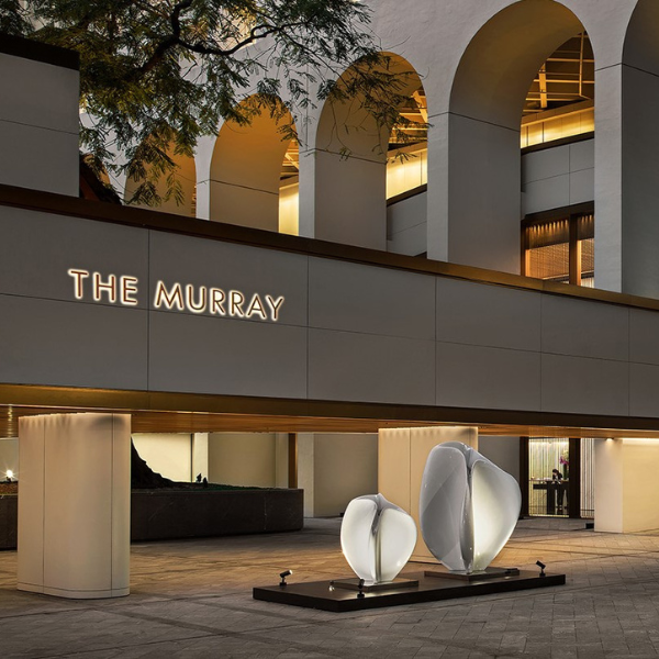a building with a sign and a couple of sculptures