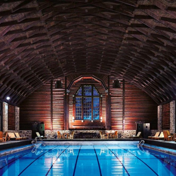 a indoor swimming pool with chairs and a large window