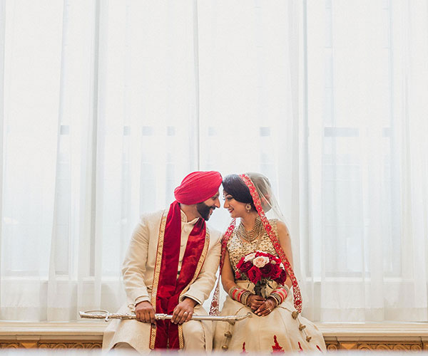 a man and woman in traditional attire sitting on a bench