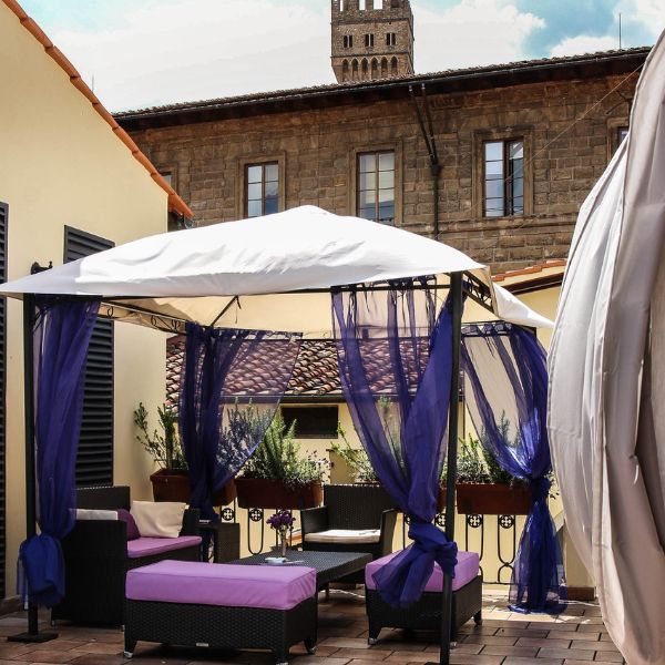 a patio with purple curtains and a white canopy