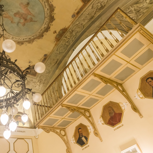 a chandelier with a balcony and paintings on the ceiling