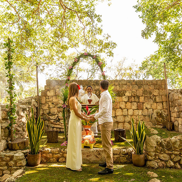 a man and woman holding hands under a arch