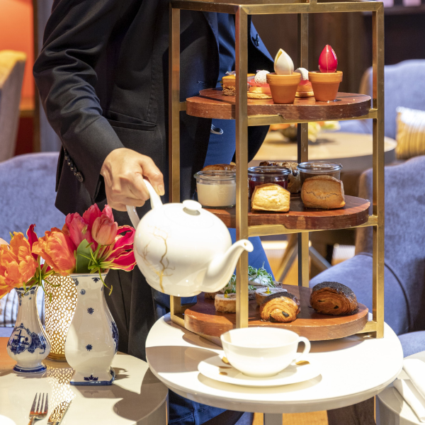 a person pouring tea into a tray of food