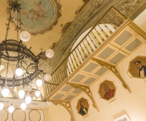 a chandelier in a room with paintings on the wall