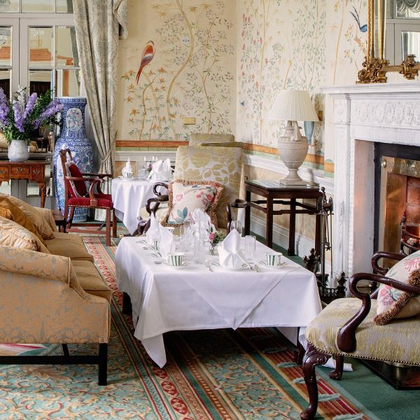 a room with a fireplace and a table with white tablecloths