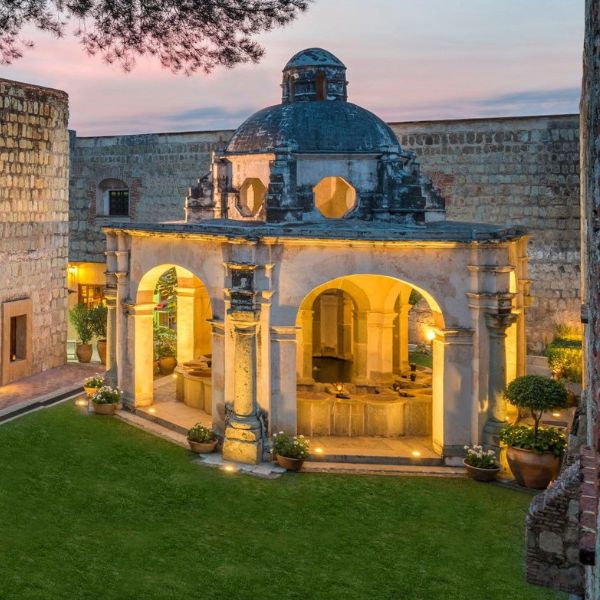 a courtyard with a stone building and a stone wall