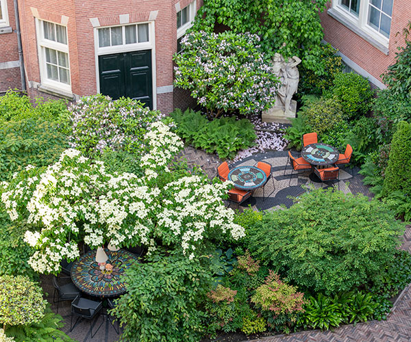 a courtyard with tables and chairs and trees