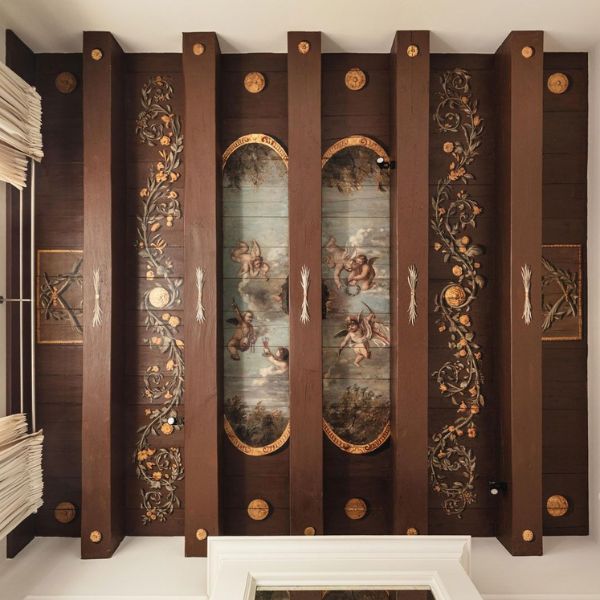 a wood paneled ceiling with art on it