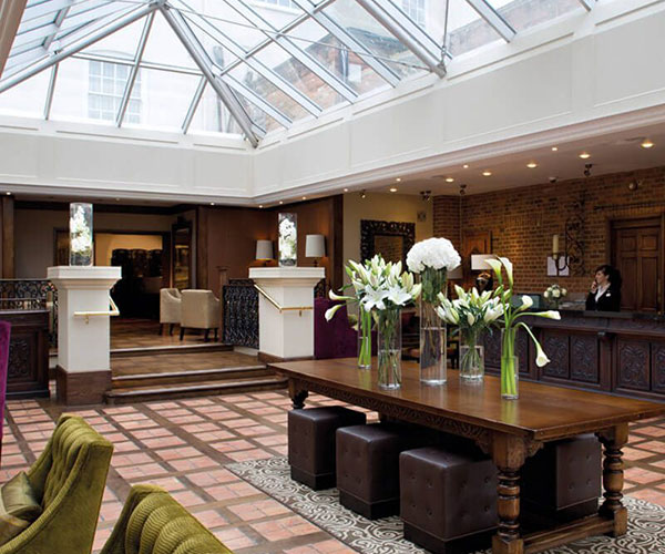 a room with a glass roof and a table with flowers