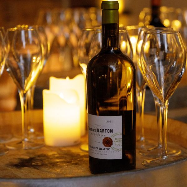 a bottle of wine on a table with wine glasses and a candle