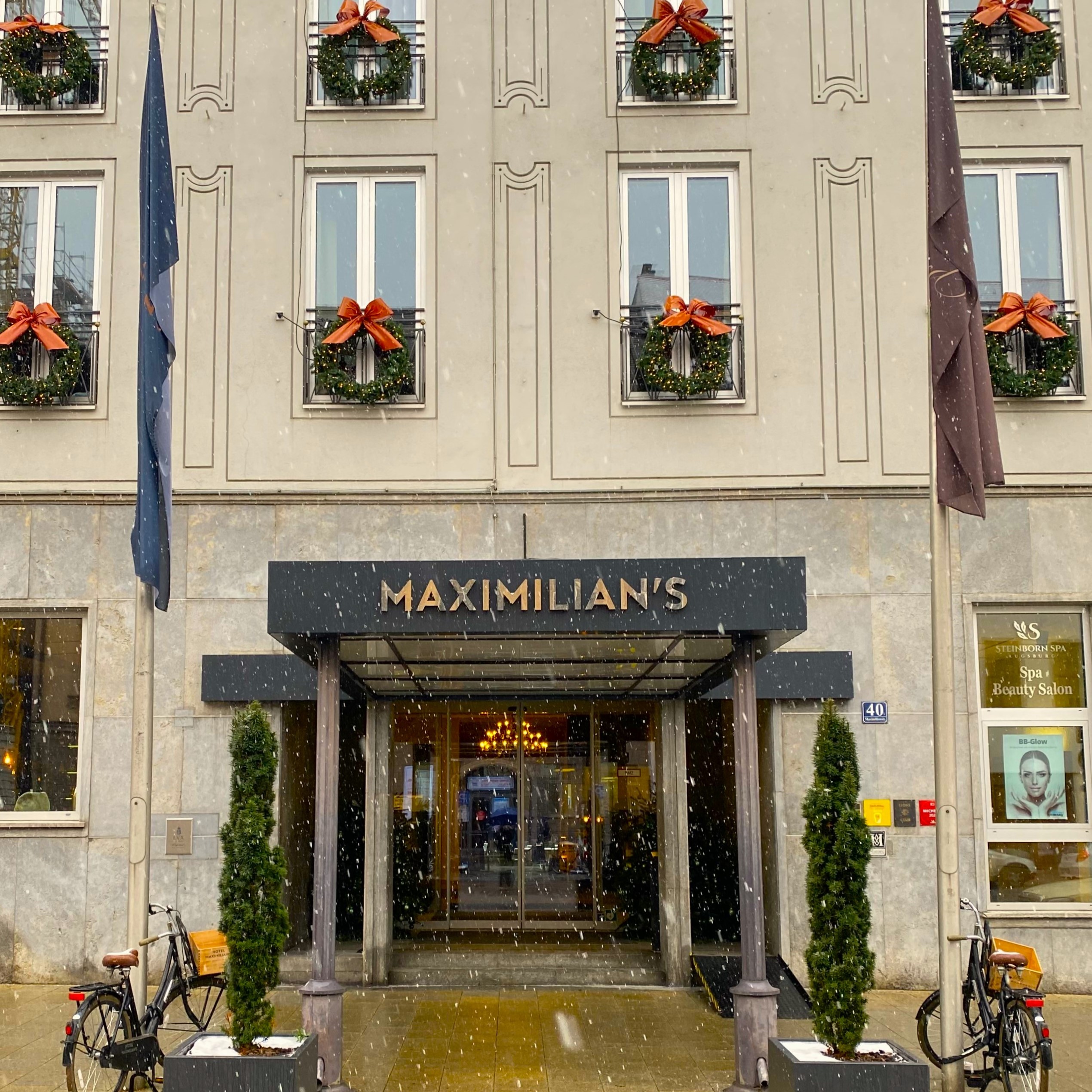 a building with christmas wreaths and flags