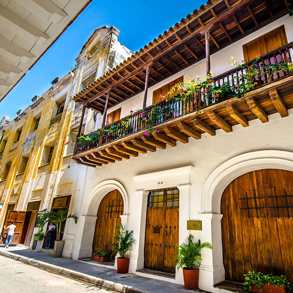 a building with a balcony and plants on the side