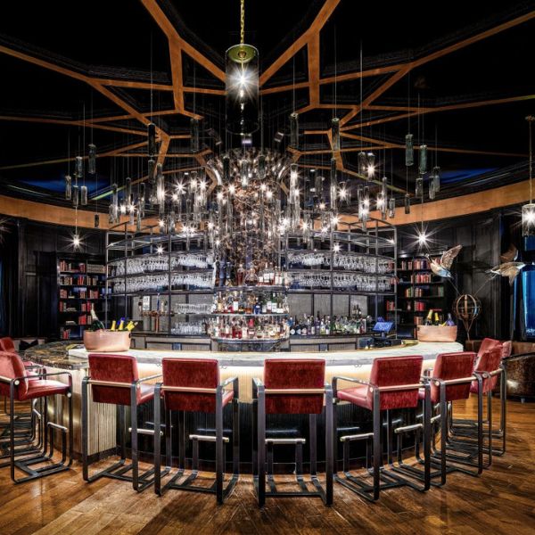 a bar with a chandelier and chairs