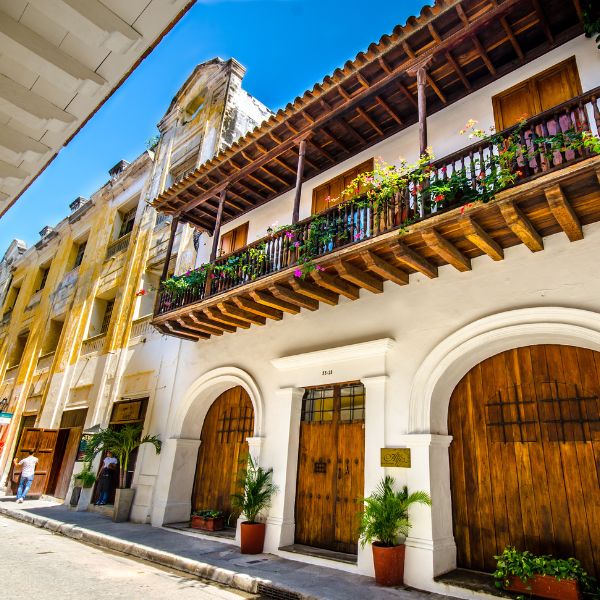 a building with a balcony and plants on the side