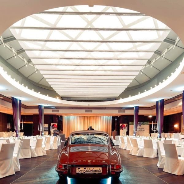 a car parked inside a room with tables and chairs