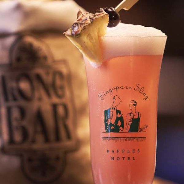 a glass of pink drink with a pineapple on top