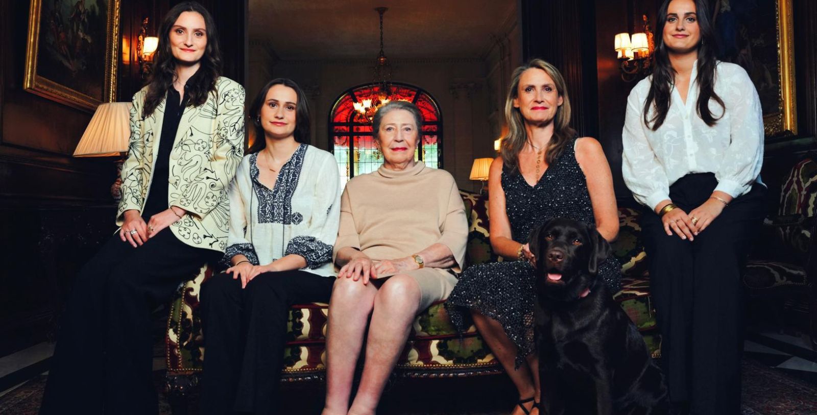 a group of women sitting on a couch with a dog