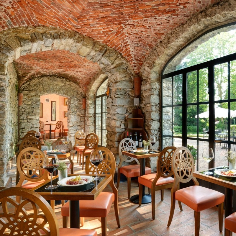 a room with tables and chairs and a brick arch