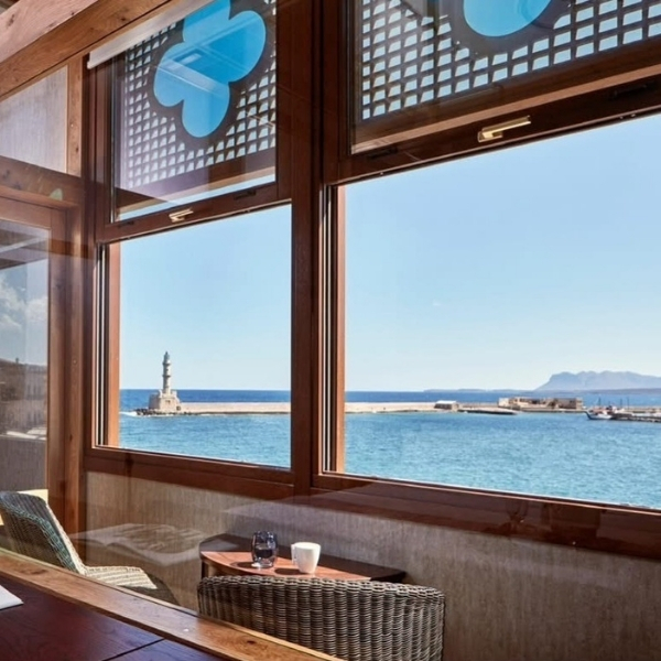 a room with a table and chairs and a view of the ocean