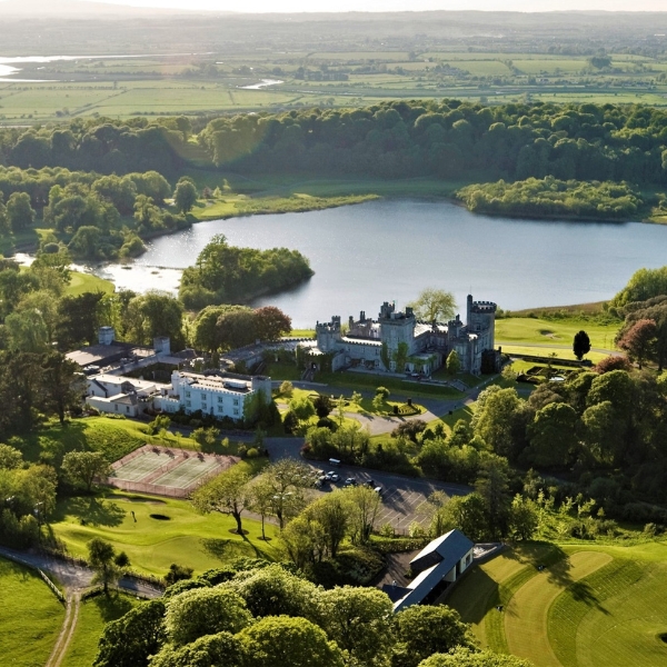 a castle surrounded by trees and a lake