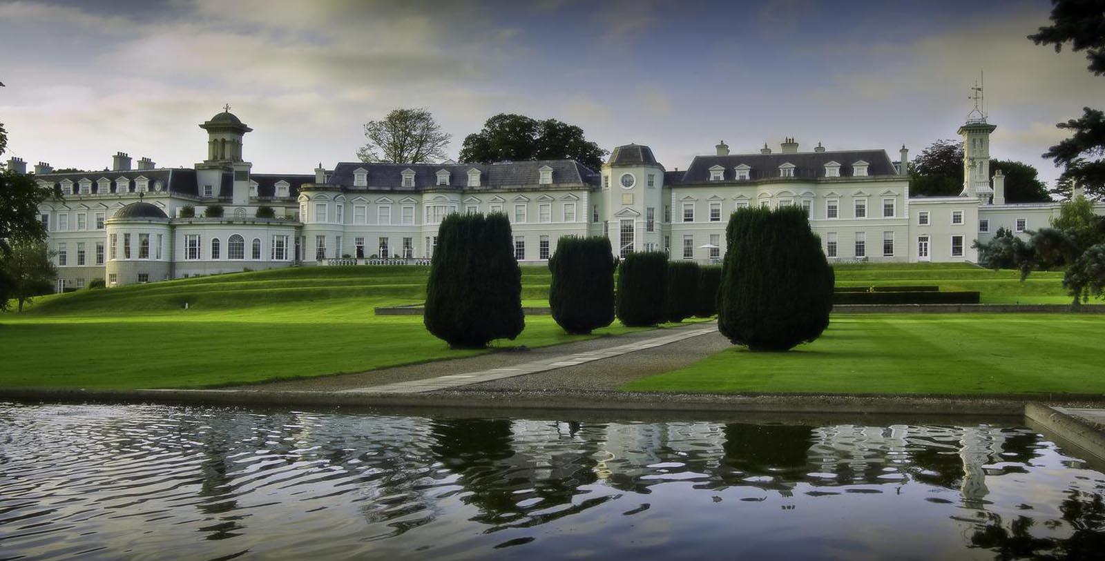 a large white building with a lawn and trees in front of it 9