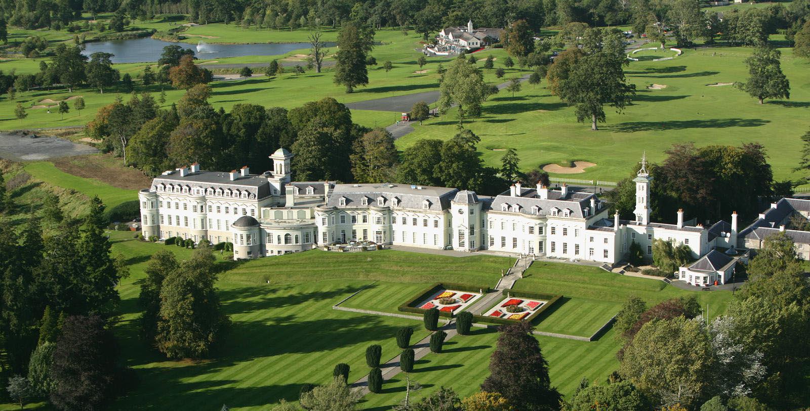 a large white building with a lawn and trees 16