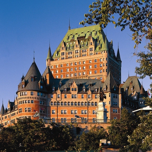 a large building with many windows with Château Frontenac in the background
