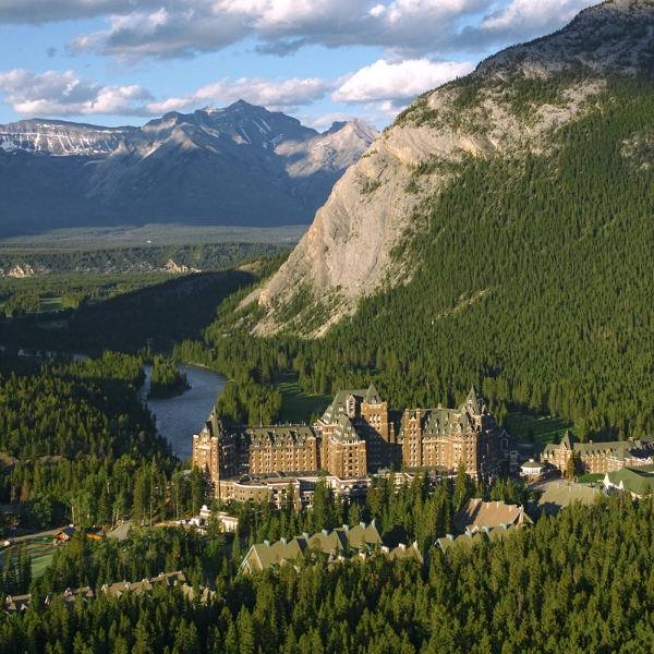 a large building surrounded by trees and mountains
