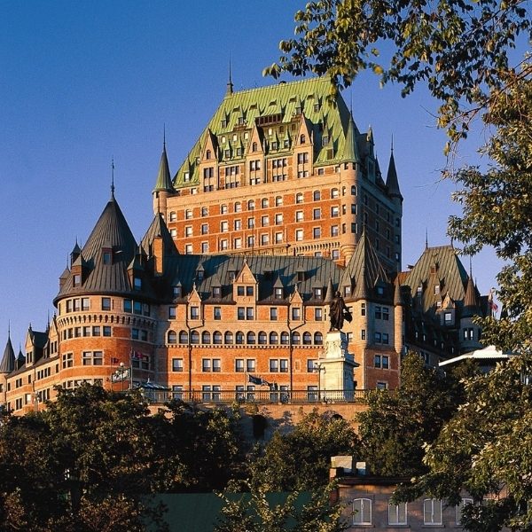 a large building with many windows with Château Frontenac in the background