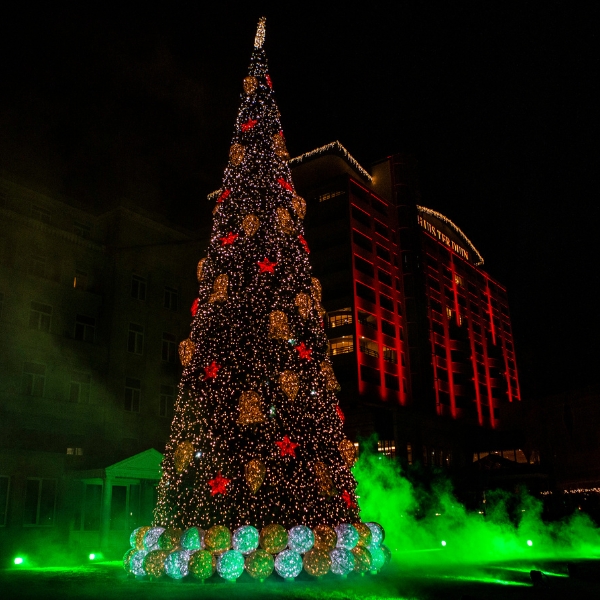 a large christmas tree with lights and smoke