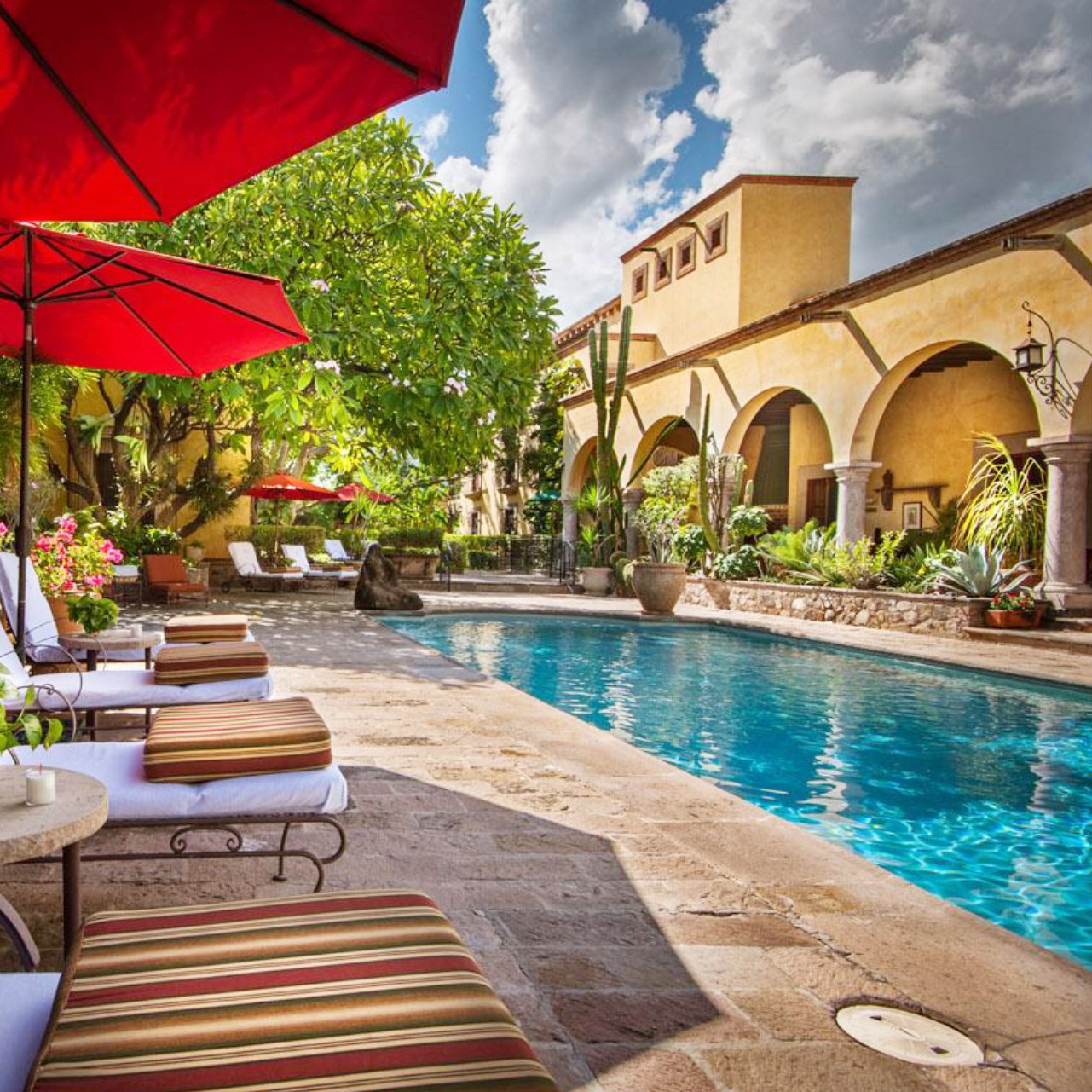 a pool with chairs and umbrellas