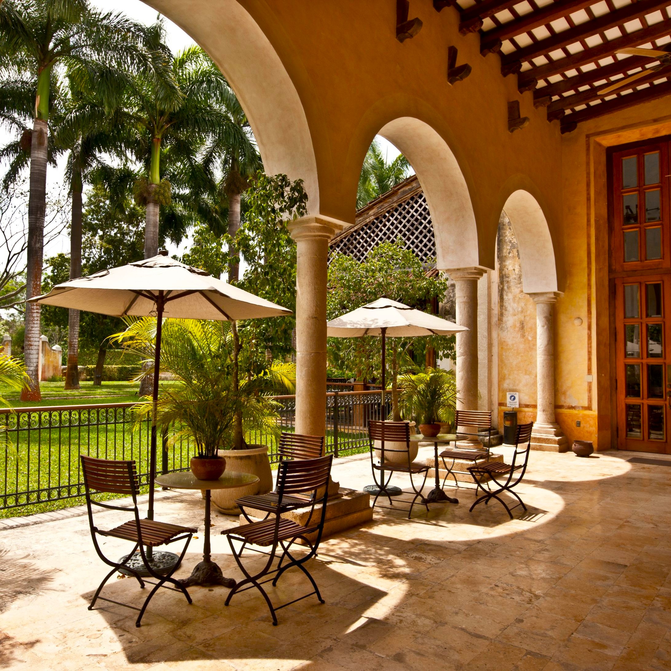 a patio with chairs and umbrellas