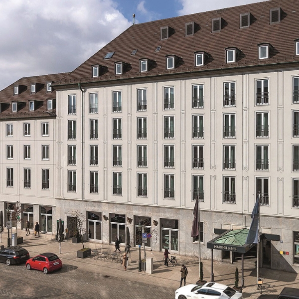 a building with many windows and cars parked on the street