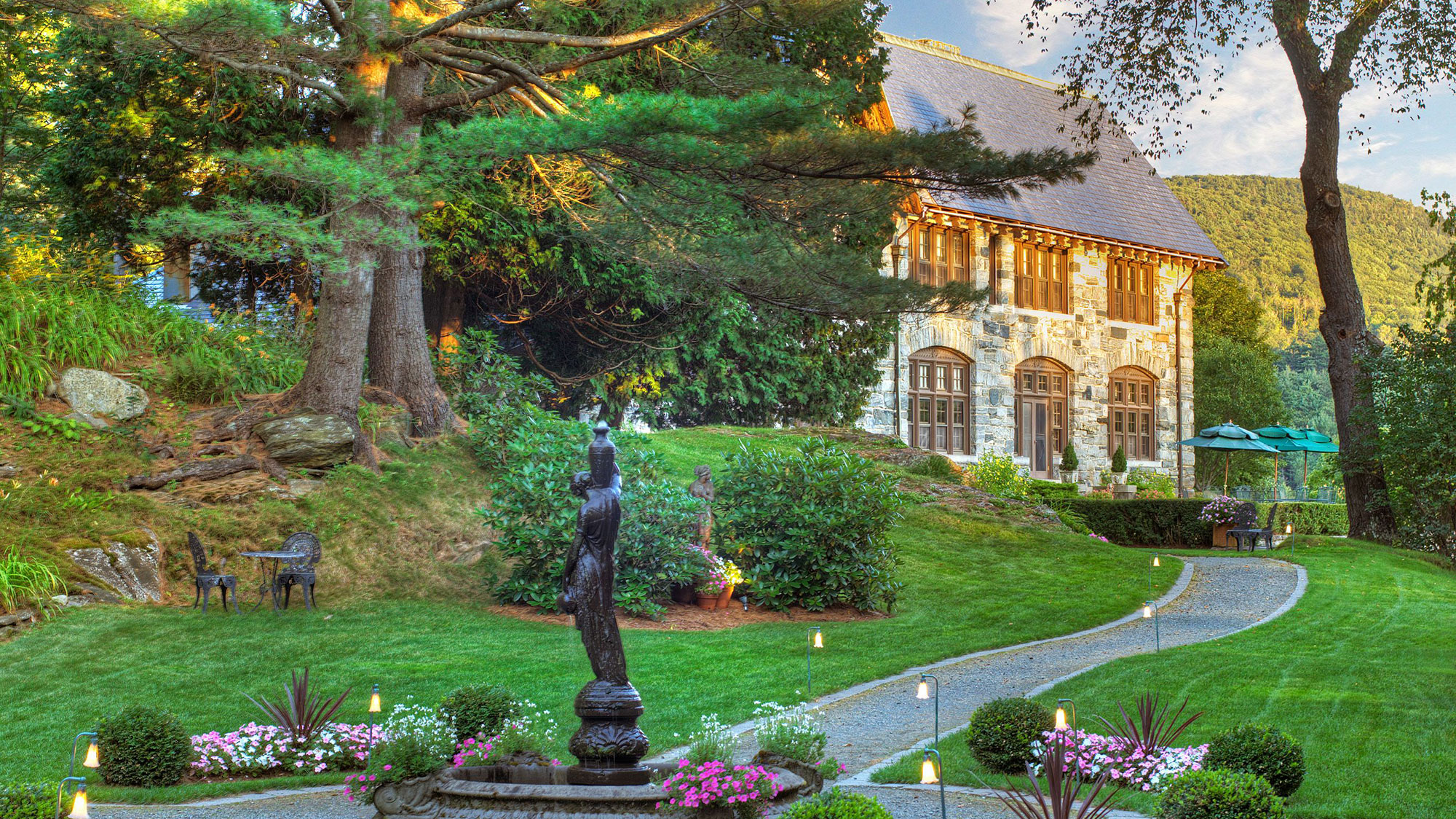 a stone path with a statue in the middle of a garden 9