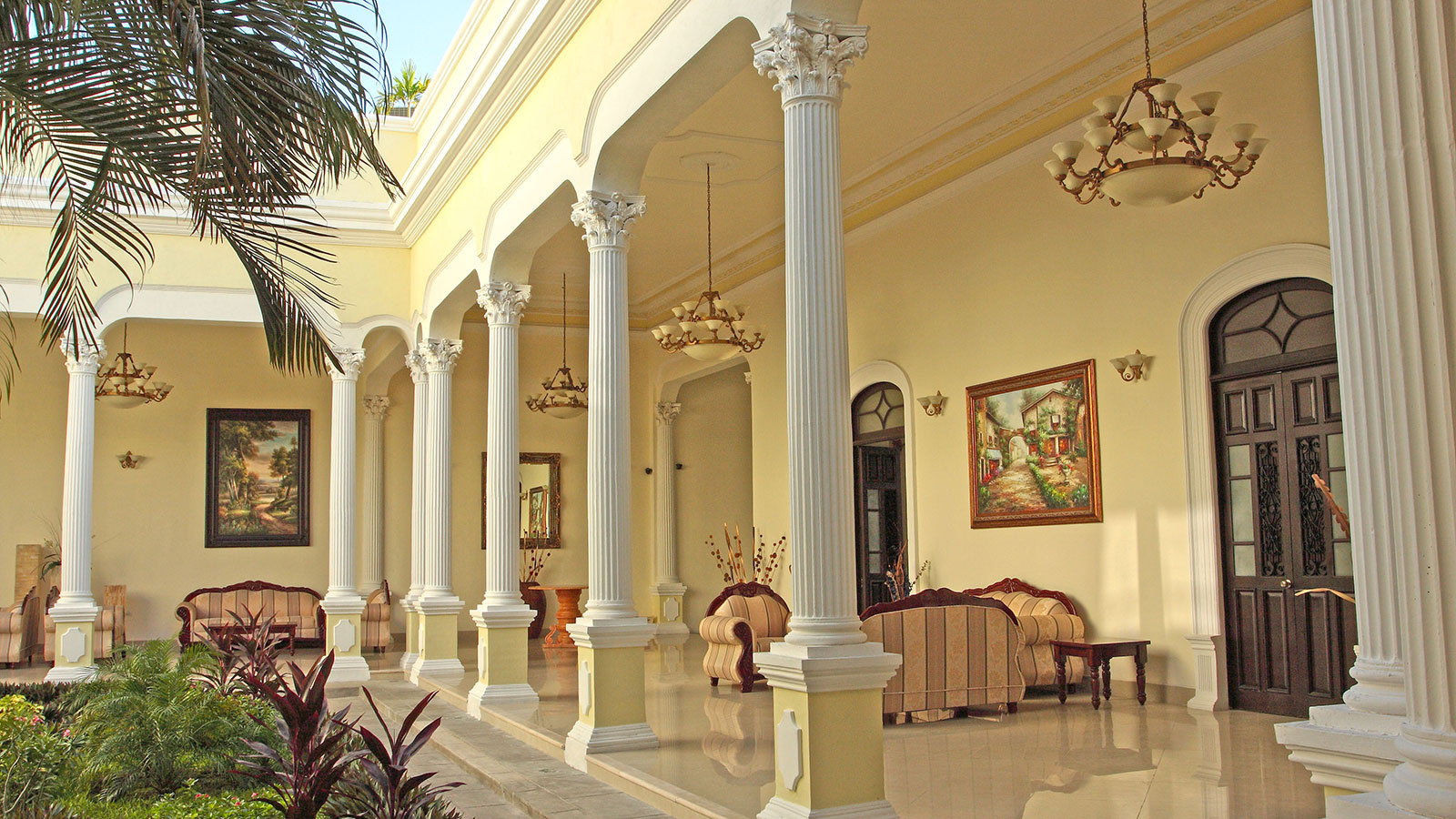 a large white building with columns and a couch 17