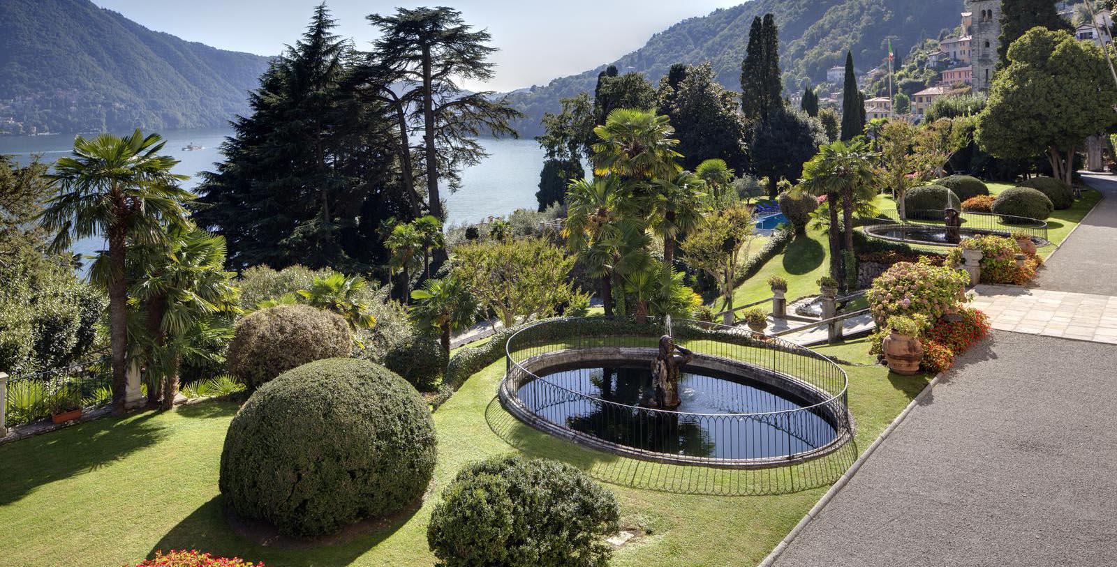 a fountain in a garden with a body of water 22