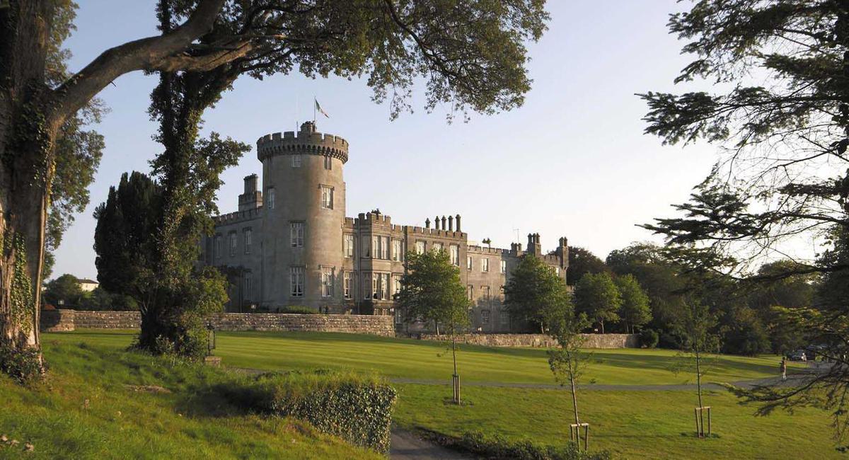 a castle with a lawn and trees