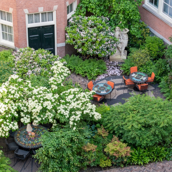 a courtyard with tables and chairs and trees