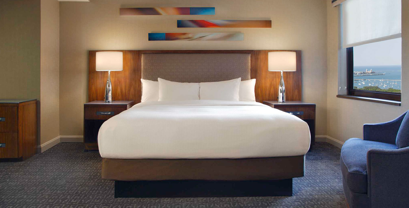 a bed with white sheets and two lamps