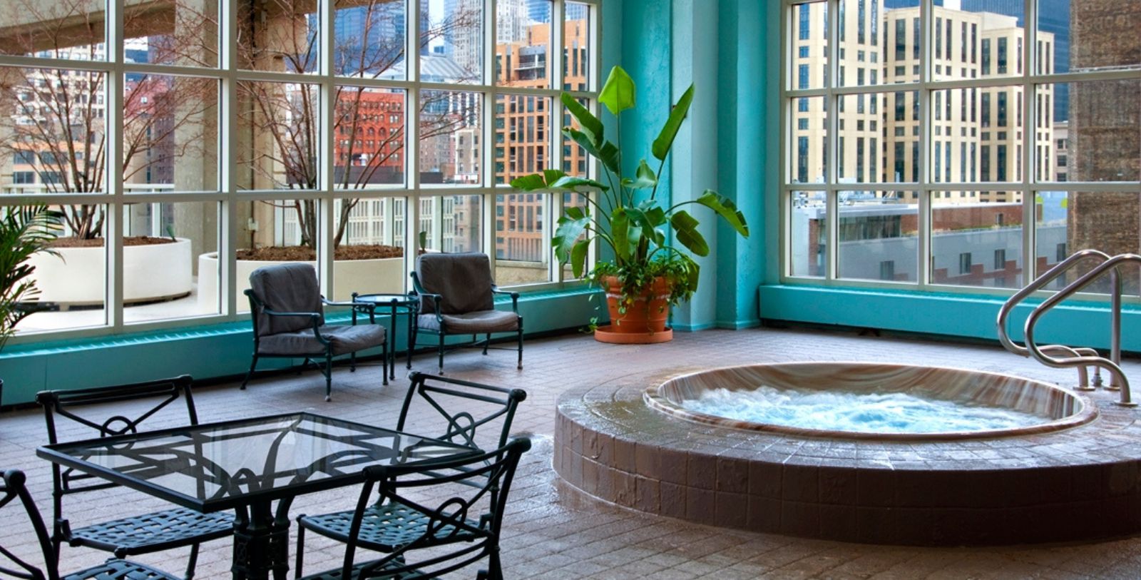 a room with a hot tub and chairs